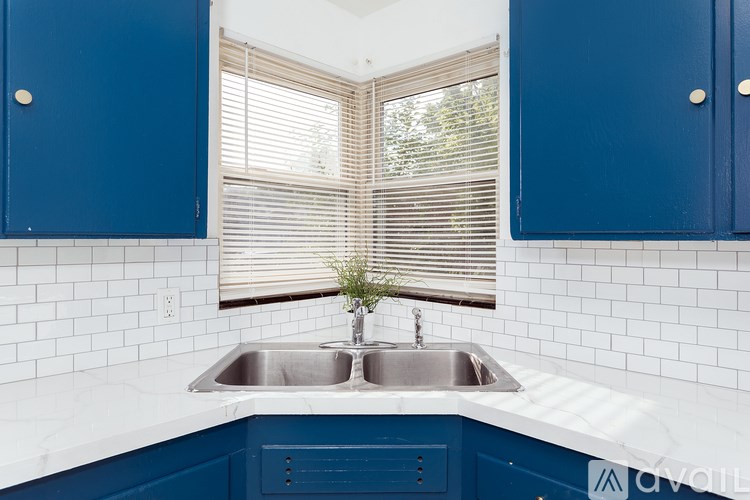 A kitchen with blue cabinets and a white countertop.