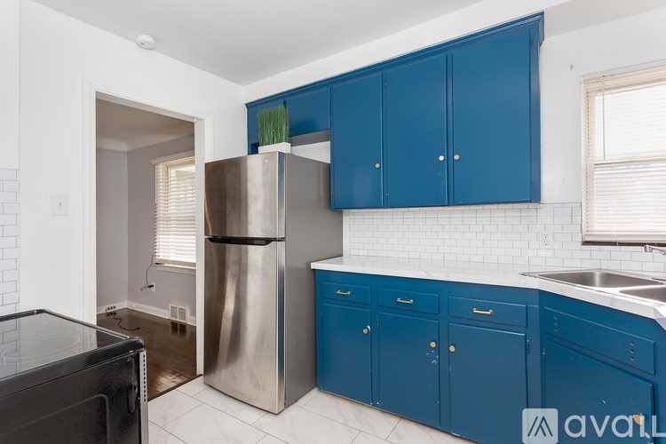 A kitchen with blue cabinets and a stainless steel refrigerator.