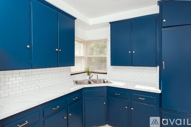 A kitchen with blue cabinets and a white countertop.