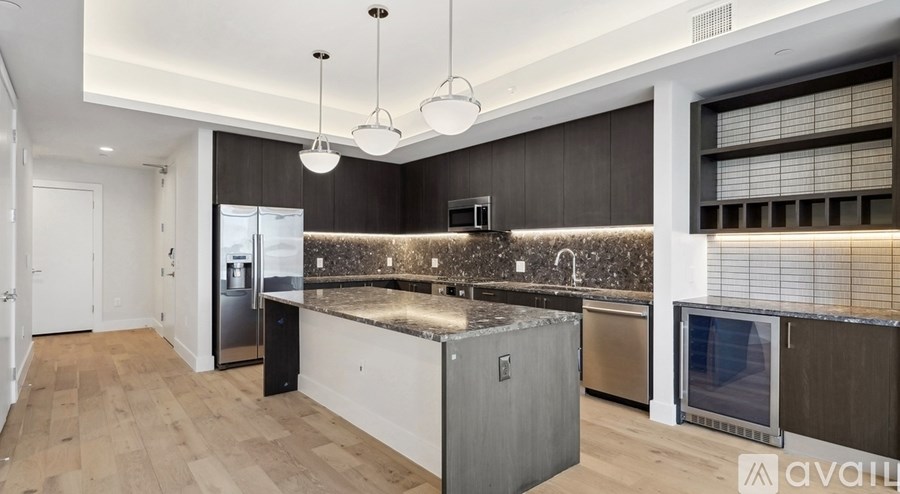 A modern kitchen with a wooden floor and a large island.