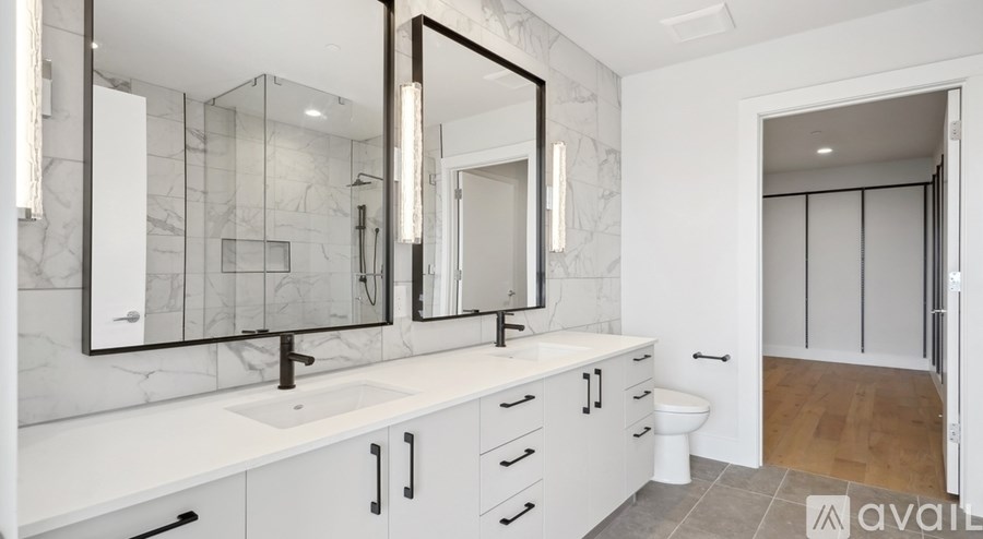A bathroom with a marble wall and a sink with a mirror above it.