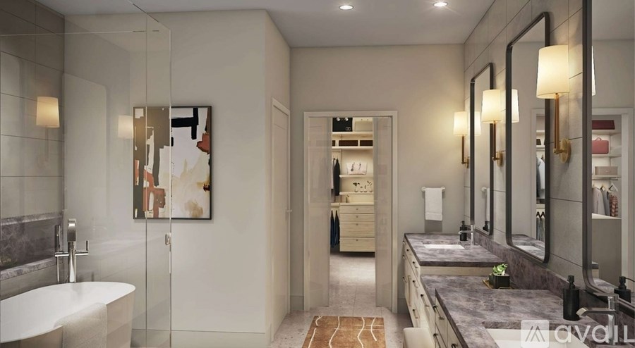 A bathroom with a white tub and a large mirror.