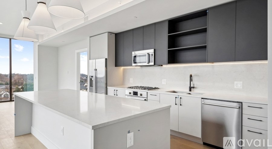 A modern kitchen with a large island and stainless steel appliances.