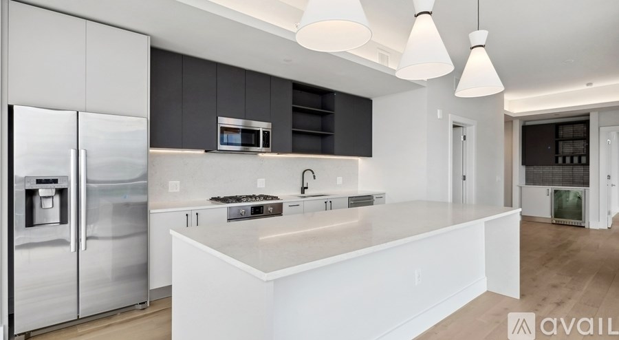 A modern kitchen with a white island and stainless steel appliances.