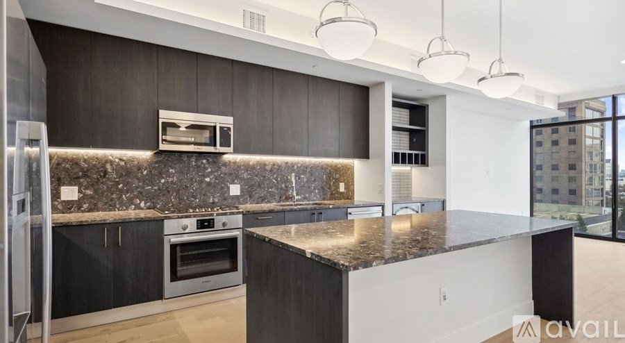 A modern kitchen with dark wood cabinets and a granite countertop.