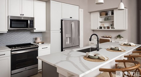 A modern kitchen with white cabinets and appliances.