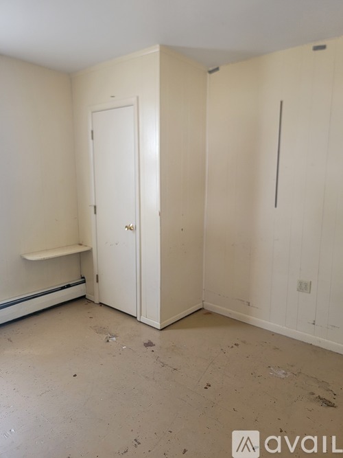 A room with a white door and a white bench against the wall.