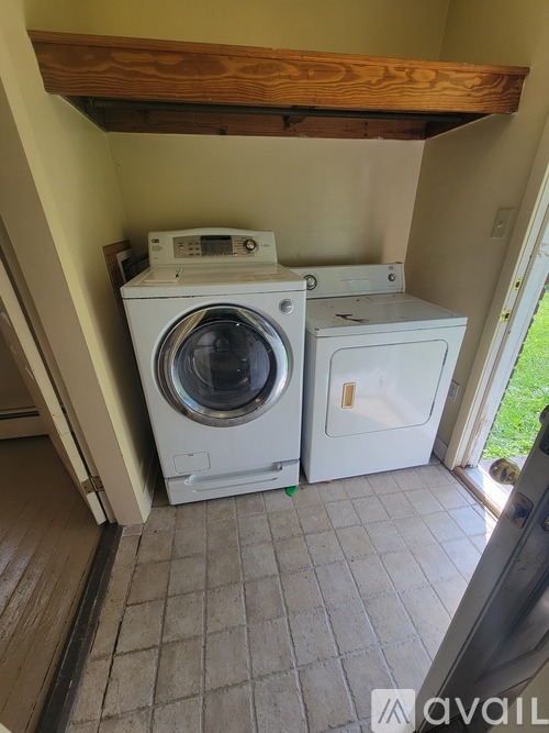 A washing machine and dryer are sitting in a small, enclosed space.
