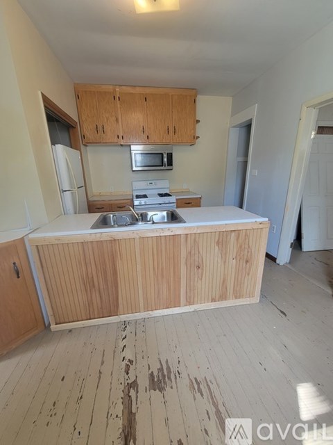 A kitchen with wooden cabinets and a white countertop.
