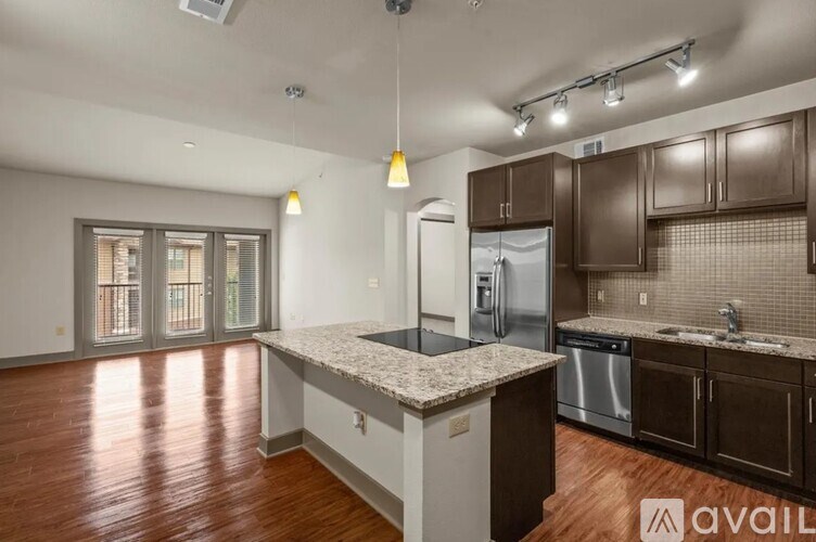 A kitchen with brown cabinets and a granite countertop.
