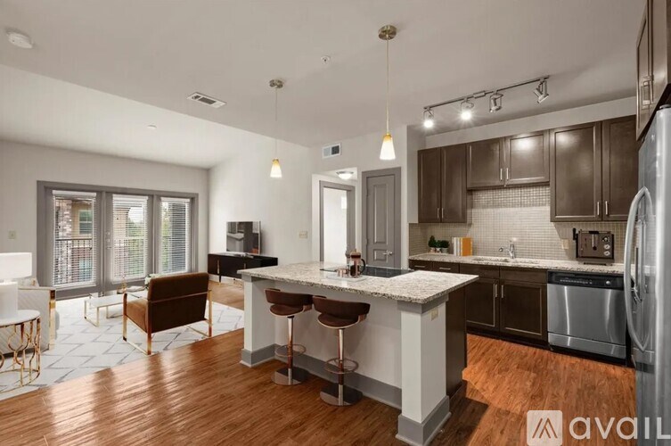A kitchen with a white island and dark wood floors.