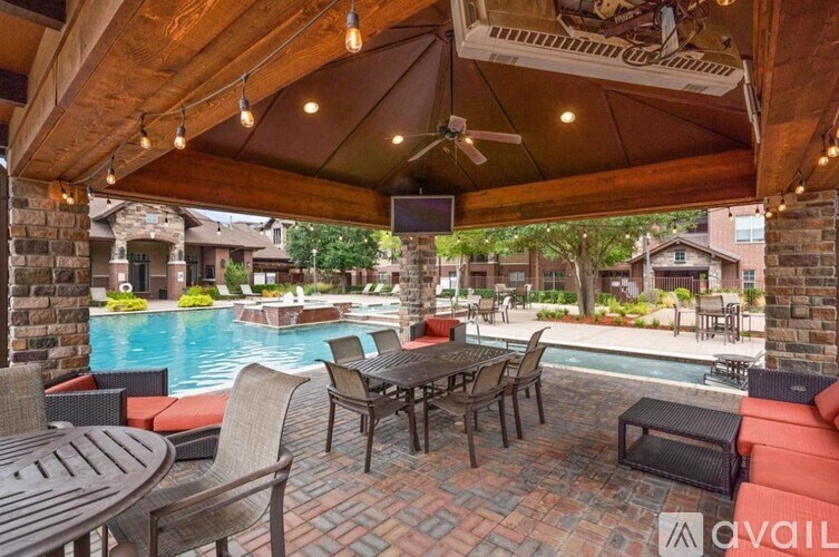 A patio with a table and chairs overlooking a pool.