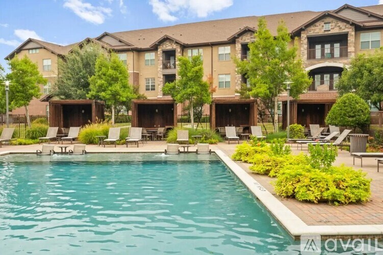 A large swimming pool in front of a multi-story apartment building.