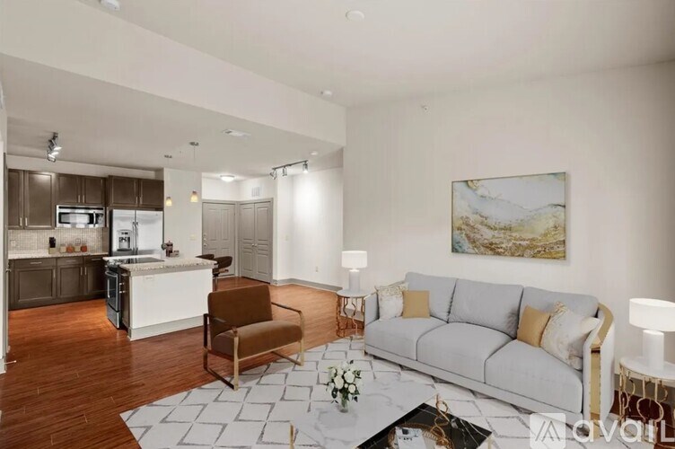 A living room with a grey couch, a brown chair, and a coffee table.