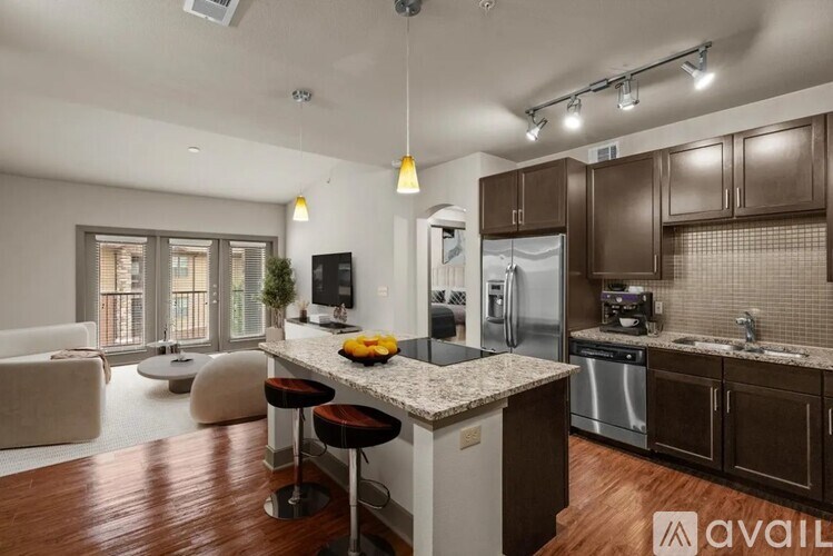 A modern kitchen with a bar stool and a fridge.