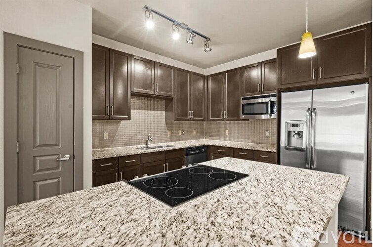 A kitchen with a granite countertop and stainless steel appliances.