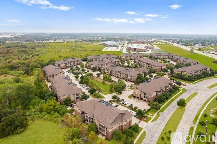 A bird's eye view of a residential area with houses and greenery.