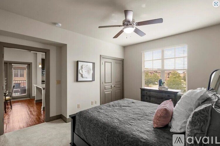 A bedroom with a bed, dresser, and a ceiling fan.