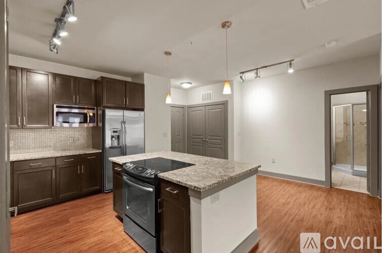 A kitchen with dark brown cabinets and a granite countertop.