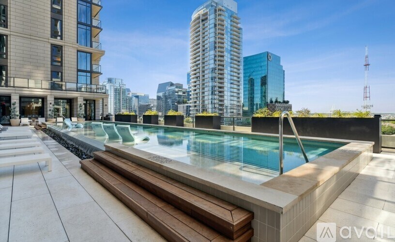 A modern pool area with a view of the city skyline.
