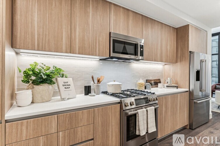 A modern kitchen with wooden cabinets and a stainless steel stove.