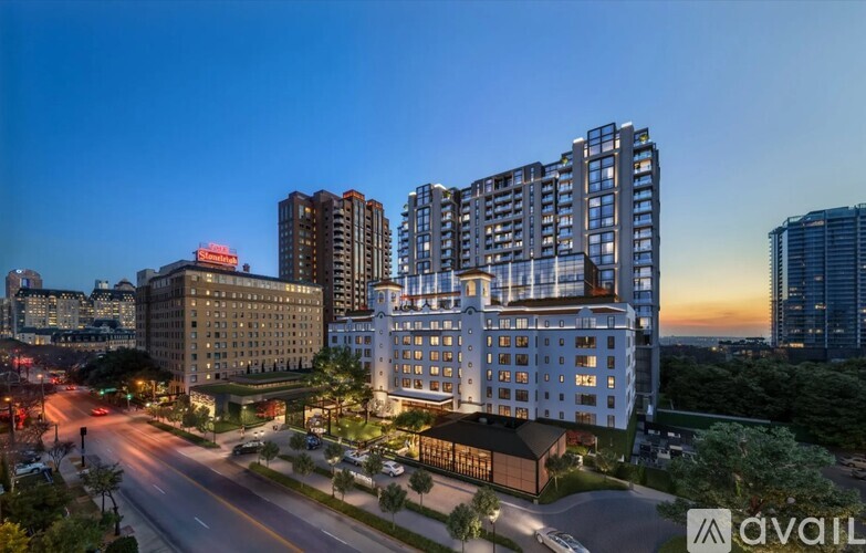 A cityscape at dusk with a road leading to a large building with the logo "avail" on it.
