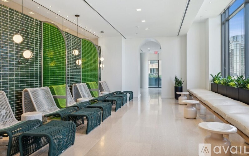 A row of green chairs are lined up in a waiting area.