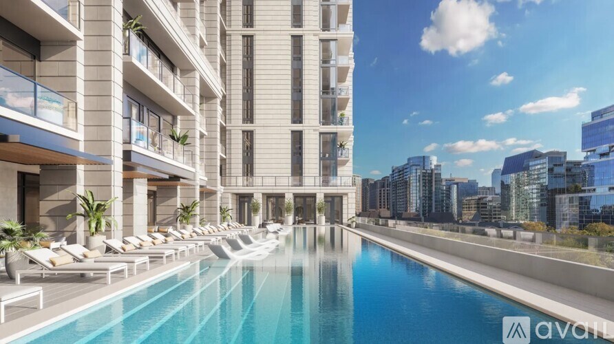 A modern building with a pool in the foreground and a cityscape in the background.