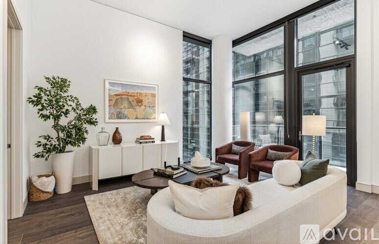 A living room with a white couch, a coffee table, and a large window.