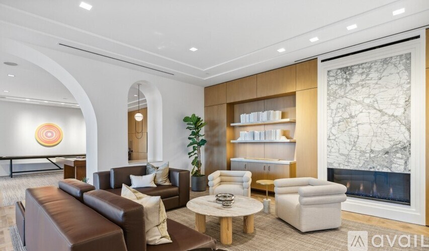 A living room with a brown leather couch and a white armchair.
