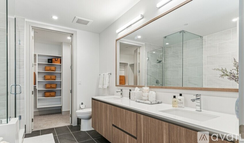 A bathroom with a white toilet, a sink with a mirror, and a shower with a glass door.