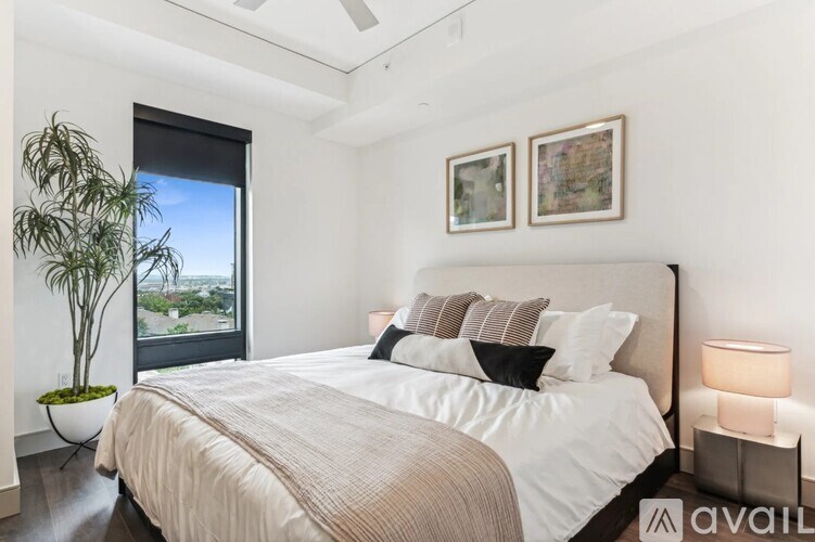 A bedroom with a large bed and a plant on a table.