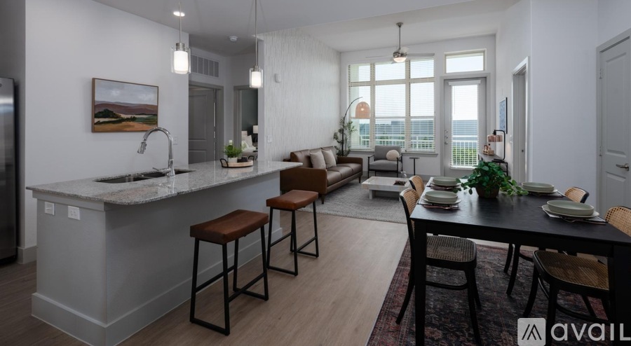 A modern kitchen with a bar stool and a dining table set for four.