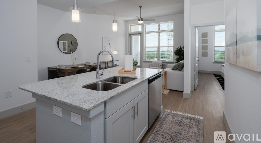 A modern kitchen with a marble countertop and stainless steel appliances.