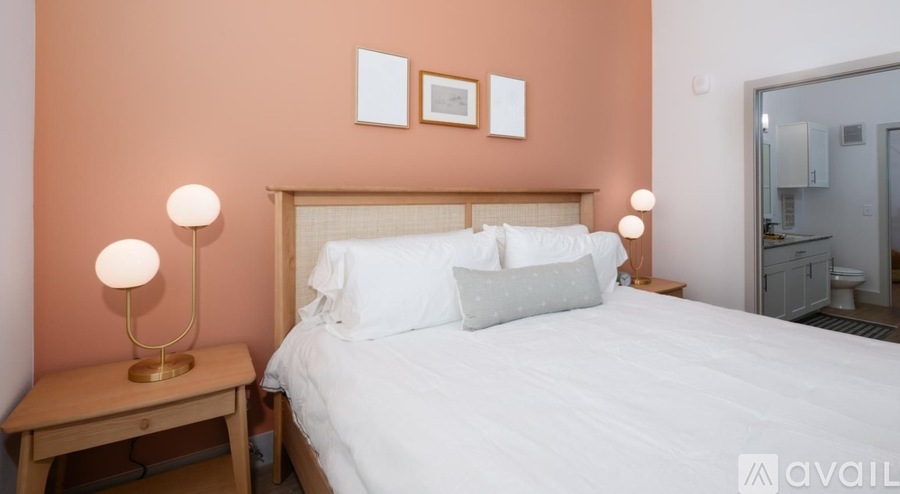 A bedroom with a bed, nightstand, and lamp.