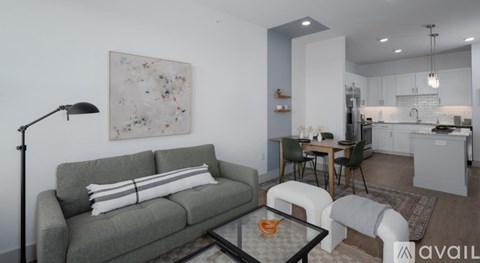 A living room with a grey couch and a glass coffee table.
