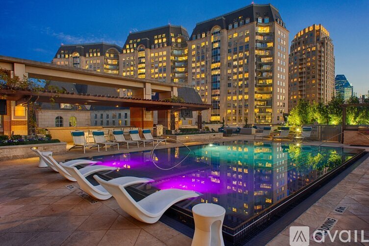 A modern poolside area with a pool and lounge chairs.