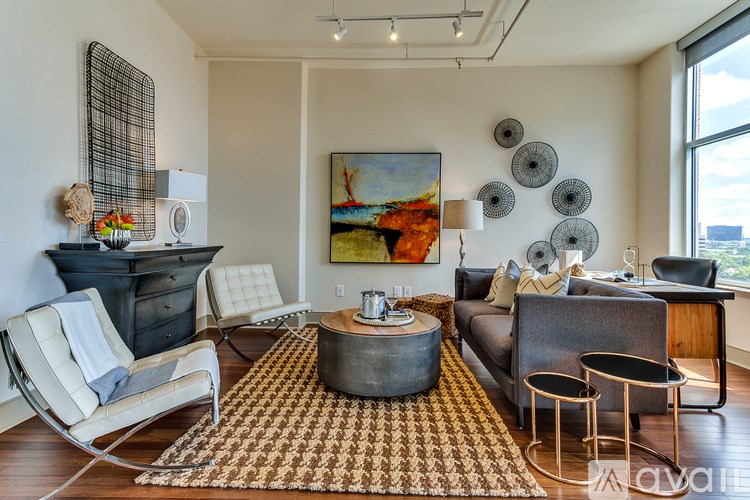 A living room with a large painting on the wall and a variety of furniture.