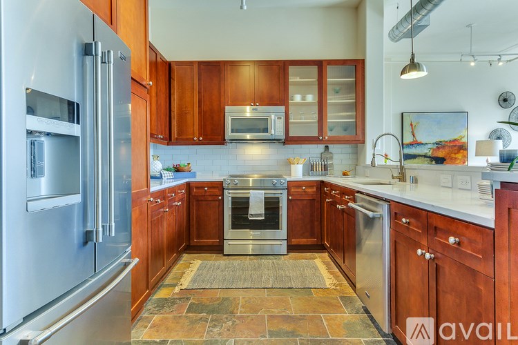 A kitchen with wooden cabinets and a tiled floor.