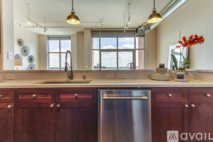 A kitchen with wooden cabinets and a stainless steel dishwasher.