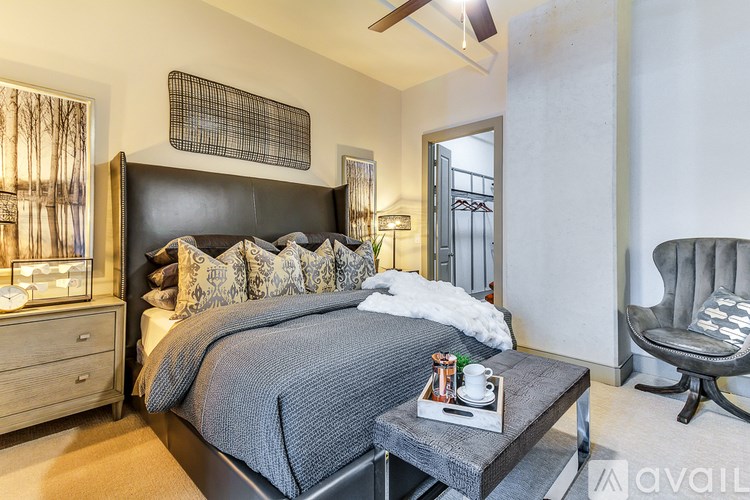 A modern bedroom with a large bed and a chair.