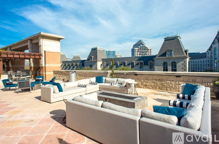 A patio with a couch and chairs with a building in the background.