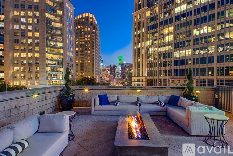 A rooftop patio with a fire pit and couches.