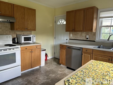 A kitchen with wooden cabinets and a white stove.