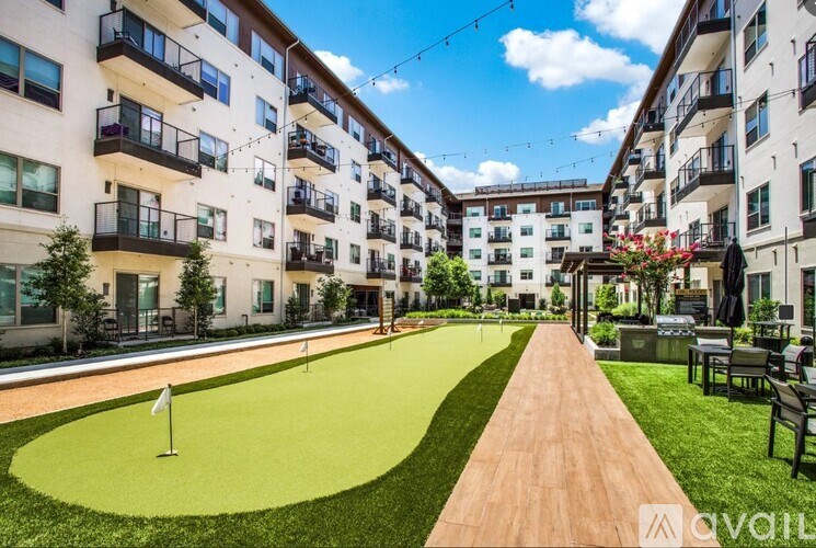 A sunny day at apartment complex with a green lawn and a walking path.