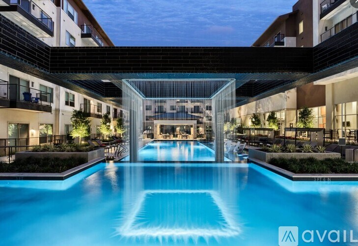 A large pool in the middle of a building surrounded by plants.