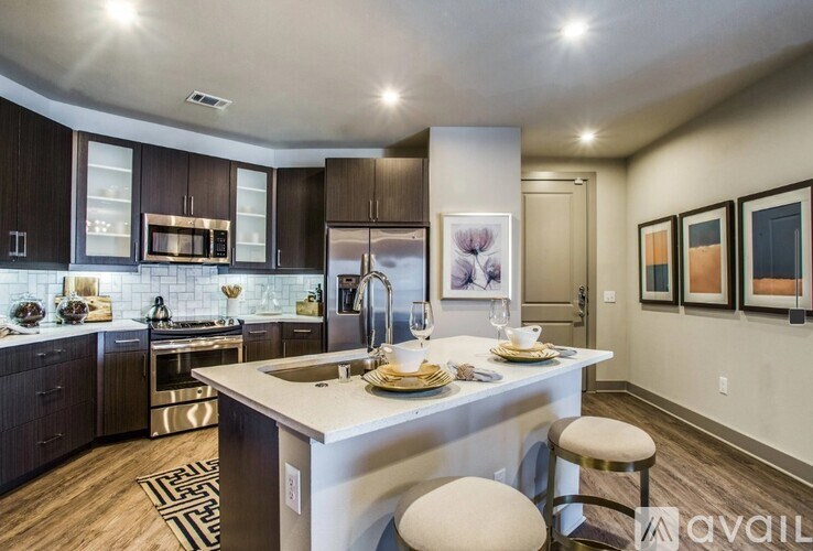 A modern kitchen with a center island and bar stools.