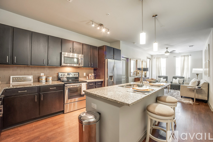 A modern kitchen with dark wood cabinets and stainless steel appliances.