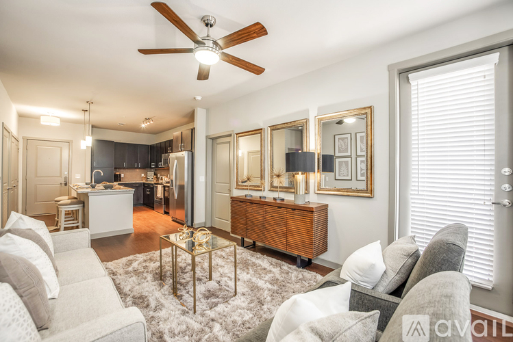 A living room with a white couch, a coffee table, and a ceiling fan.