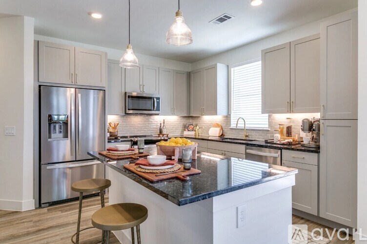 A kitchen with a large island and stainless steel appliances.